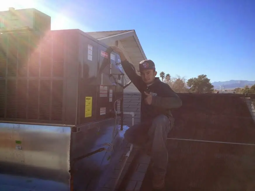 HVAC technician performing AC Tune-Up on a rooftop unit in Susquehanna